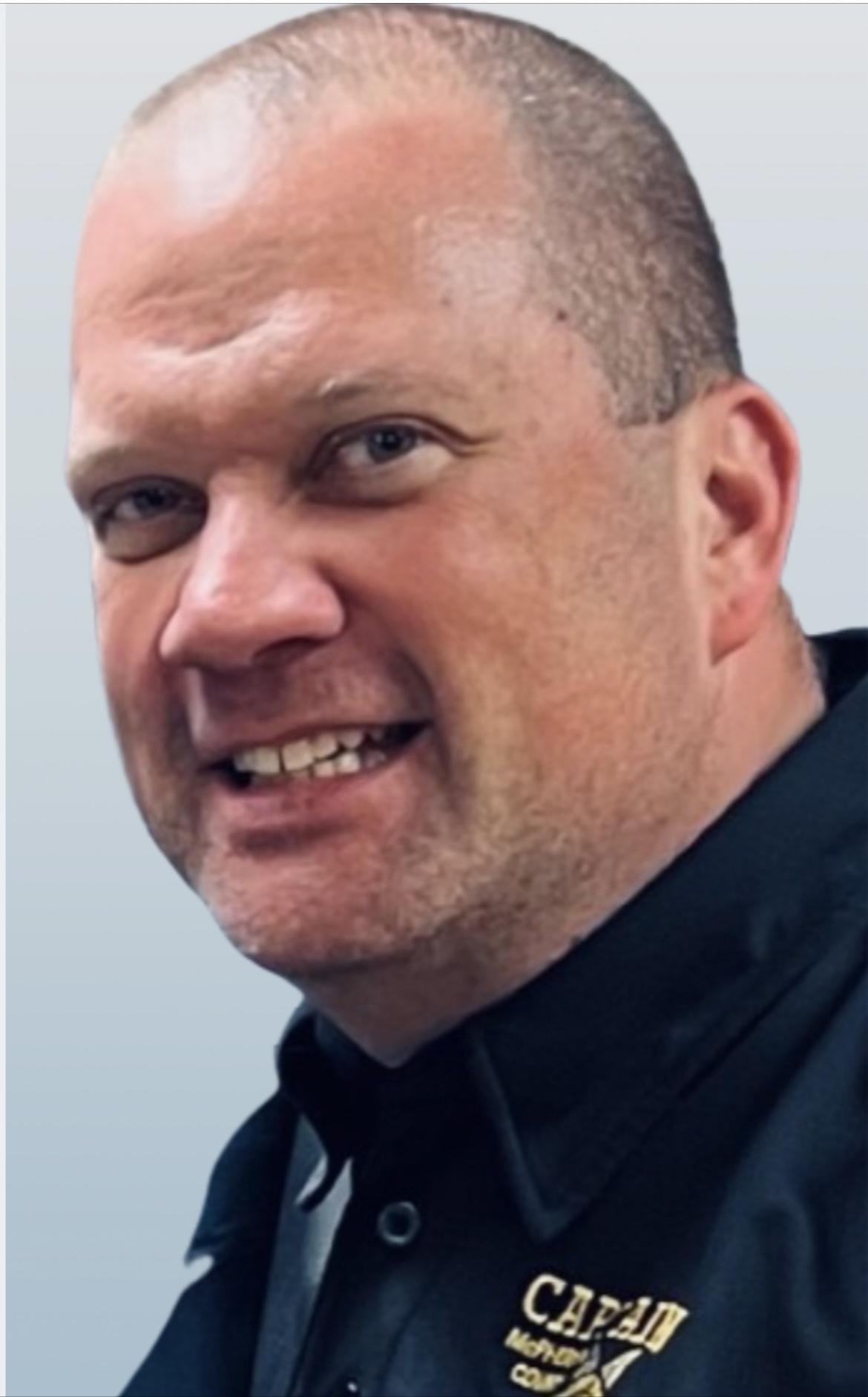 Person sitting in a chair wearing a VR headset with computer monitor and panel in background.